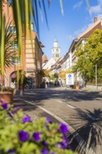 A lively street in a town with historic buildings and a church tower, Überlingen, Lake Constance,