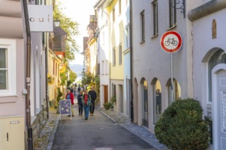 A narrow, sunny alley with pedestrians and various small shops, Überlingen, Lake Constance, Germany