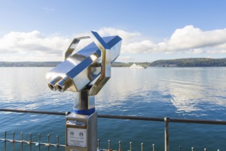 Metallic binoculars pointing to the lake with a peaceful view of the shore, Überlingen, Lake