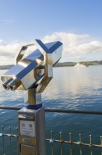 Binoculars on the shore with a ship in the background on the calm lake, Überlingen, Lake Constance,