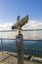 Binoculars on the lakeshore looking over calm water under a blue sky, Überlingen, Lake Constance,