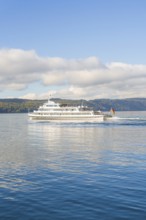 Passenger ship moving on a calm lake under a cloudy sky, Überlingen, Lake Constance, Germany