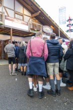 Group of people in traditional Bavarian traditional costume in front of a venue, Cannstatter Wasen