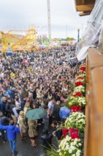Many people at a lively folk festival, colourful flowers in the foreground, Cannstatter Wasen folk
