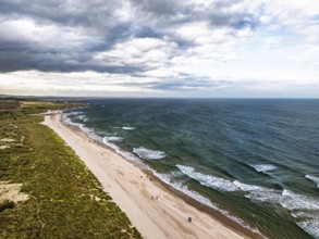 Beach and Dunes over Bamburgh Castle from a drone, Northumberland, Northeast Coast, England, United