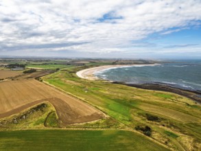 Fields and Farms over Dunstanburgh Castle from a drone, Northumberland Coast, England, United