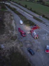 Aerial view of emergency vehicles and emergency services on railway tracks in the evening, fire