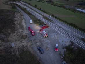 Aerial view of a rescue operation with several vehicles along the railway tracks, fire brigade