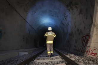 Firefighter in protective clothing enters illuminated tunnel, fire drill in the new tunnel of the