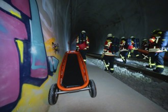 Firefighters pushing a stretcher in a tunnel with graffiti, firefighting exercise in the new