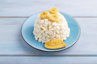 White ?ottage cheese, Curd, with Banana on blue wooden background, side view, close up