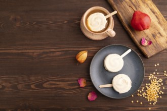 ?hocolate Ice cream in white glaze, cup of coffee, on brown wooden background, top view, flat lay,
