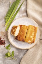 Fried crispy pancakes with meat and cheese on brown concrete background and linen textile. top