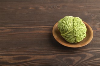 Green lettuce on plate on brown wooden background. Side view, copy space. healthy food, vegetable,