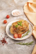 Fried Turkey Thigh with spices and rosemary on plate on brown concrete background and orange linen