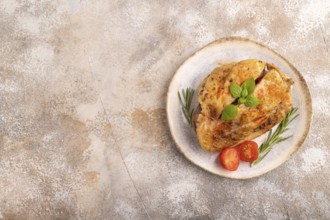 Fried Turkey Thigh with spices and rosemary on plate on brown concrete background. top view, flat