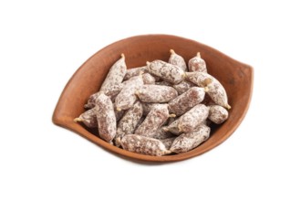 Small smoked Chicken sausages in clay bowl isolated on white background. side view, close up