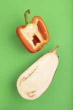 Red Cutted pepper and Purple Cutted eggplant on green pastel background. Top view, flat lay, copy