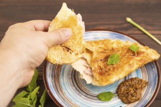 Fried homemade Khachapuri cake with cheese and meat, fried in pan with hand. Traditional Georgian