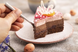 Chocolate cake with hand on brown concrete background, cup of coffee, side view, close up,