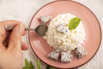 White ?ottage cheese, Curd, with Pithaya with hand on gray concrete background and linen textile,