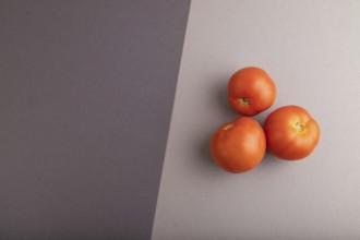 Red tomato on black and gray pastel paper background. Top view, flat lay, copy space. healthy food,