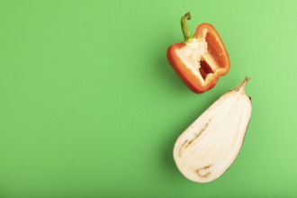 Red Cutted pepper and Purple Cutted eggplant on green pastel background. Top view, flat lay, copy