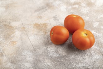 Red tomato on brown concrete background. Side view, copy space. healthy food, vegetable, minimalism
