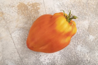 Red Heart Shape tomato on brown concrete background. Top view, flat lay, close up. healthy food,