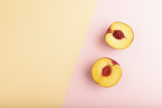 Peach Cut in half on orange and pink paper pastel background. Top view, flat lay, copy space.