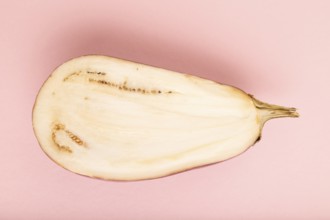 Purple Cutted eggplant with white stripes on pink pastel background. Top view, flat lay, copy space