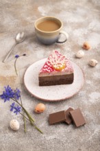 Chocolate cake on brown concrete background, cup of coffee, side view, close up