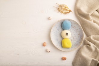 Japanese Mochi Cakes on white wooden background and linen textile, top view, flat lay, copy space