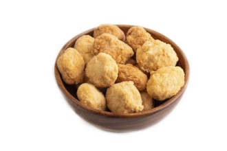 Fried crispy Chicken Nuggets in brown wooden bowl isolated on white background. side view, copy