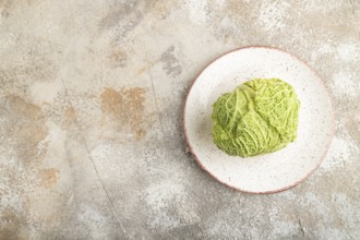 Green lettuce on plate on brown concrete background. Top view, copy space, flat lay. healthy food,