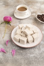 Coffee marshmallow with cup of coffee on brown concrete background. side view, close up