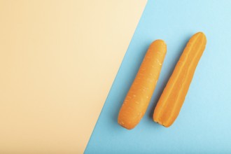 Orange Carrot on orange and blue pastel paper background. Top view, copy space, flat lay. healthy
