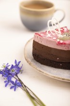 Chocolate cake on white wooden background and orange linen textile, cup of coffee, side view, close