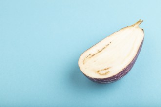 Purple Cutted eggplant with white stripes on blue pastel background. Side view, copy space.