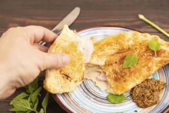Fried homemade Khachapuri cake with cheese and meat, fried in pan with hand. Traditional Georgian
