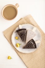 Chocolate and Vanilla Cake pops Marshmallow with cup of coffee on white wooden background and beige