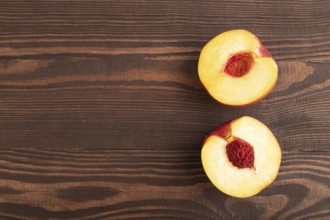 Peach Cut in half on brown wooden background. Top view, flat lay, copy space. healthy food,