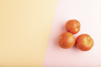 Red tomato on pink and orange pastel paper background. Top view, flat lay, copy space. healthy