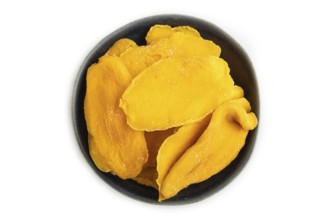 Dried Mango in blue ceramic bowl isolated on white background. Top view, close up, flat lay.