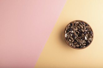 Wooden bowl with Kidney beans on pink and orange pastel paper background, top view, flat lay, copy