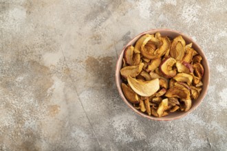 Dried Apples in ceramic bowl on brown concrete background. Top view, copy space, flat lay. healthy