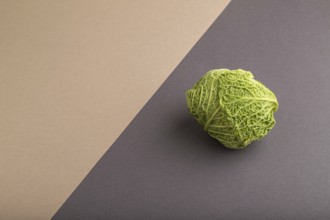 Green lettuce on beige and gray pastel paper background. Side view, copy space, flat lay. healthy