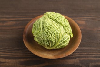 Green lettuce on plate on brown wooden background. Side view, close up. healthy food, vegetable,