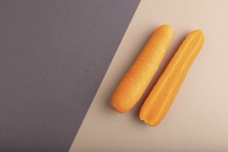Orange Carrot on beige and gray pastel paper background. Top view, copy space, flat lay. healthy