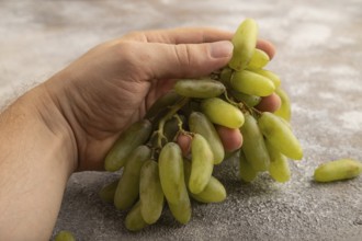 Green grapes on gray concrete background. Side view, close up. healthy food, minimalism